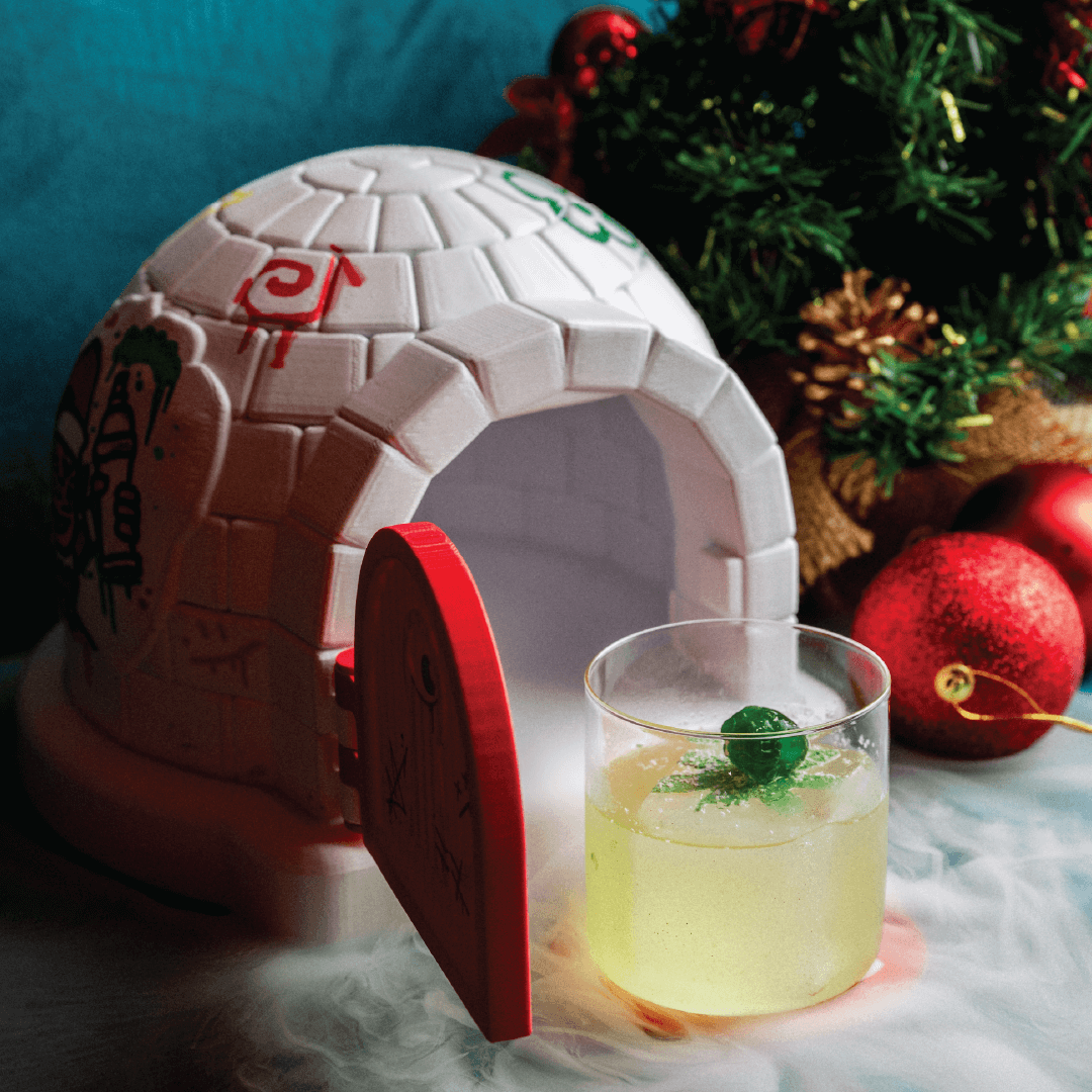 christmas themed cocktail in igloo with dry ice