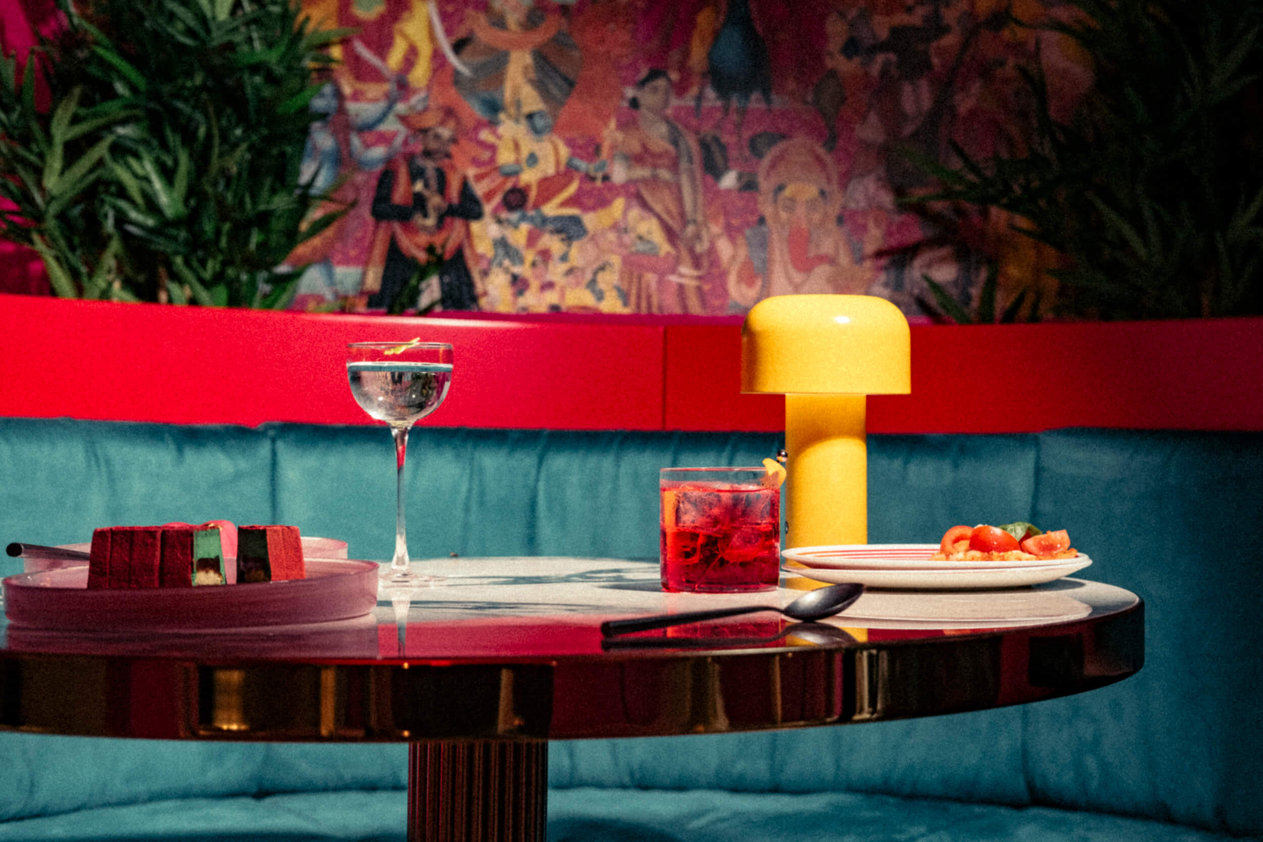 Food and drinks on a table at Kuch Kuch, a speakeasy-style cocktail bar in Malta with a curated atmosphere.