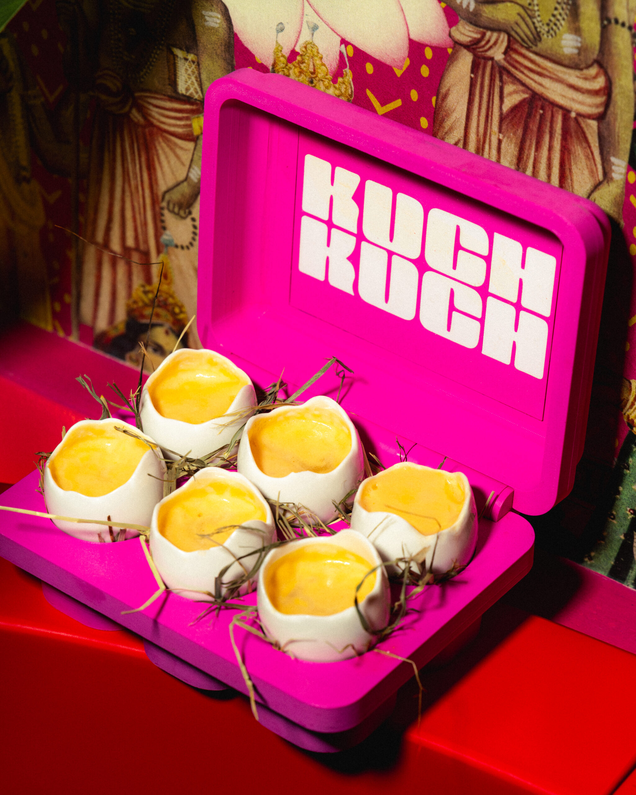 Pink Kuch Kuch branded serving box with egg shell-style cocktail shots, photographed inside an immersive cocktail bar in St Julian’s, Malta.