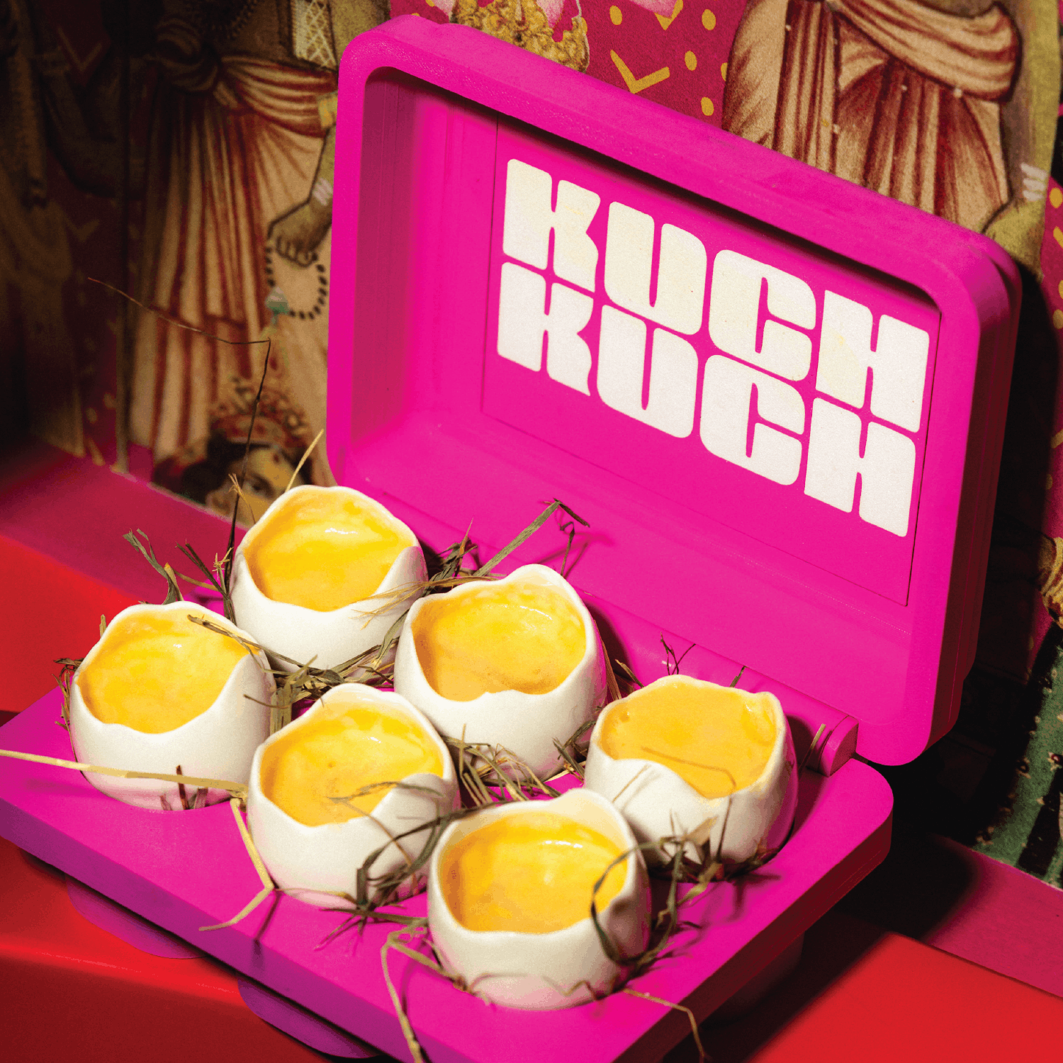 Pink Kuch Kuch branded serving box with egg shell-style cocktail shots, photographed inside an immersive cocktail bar in St Julian’s, Malta.
